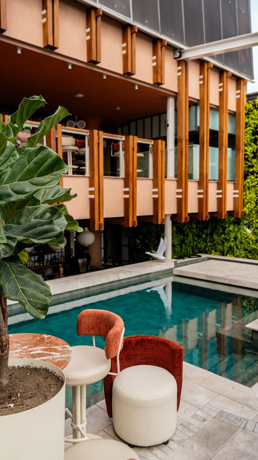 La piscine du rooftop sous la façade tressée de l'hôtel