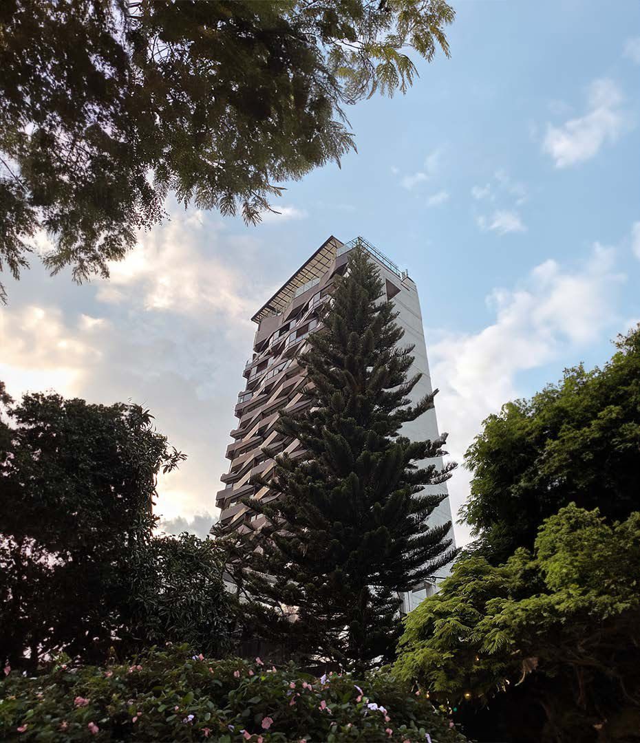 La tour du The Charlee vue entre les arbres du Parque Lleras